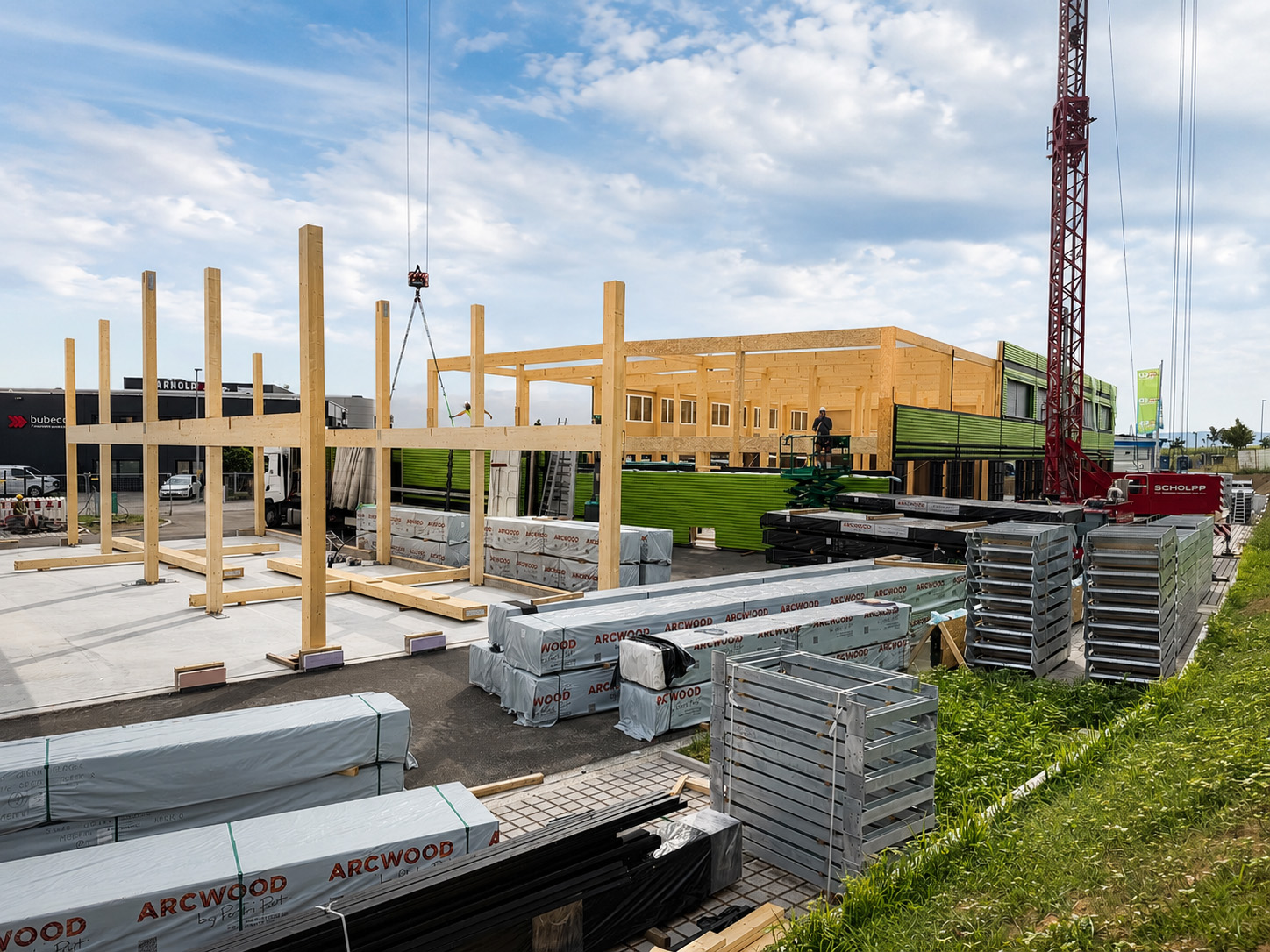 Holz- und Hybridtragwerk eines mehrgeschossigen Gewerbebaus während der Montage